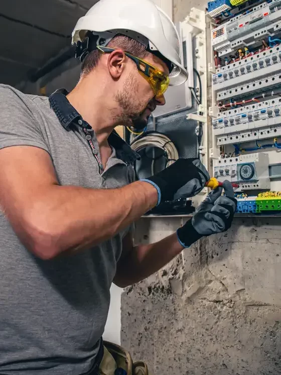 Un homme, un électricien travaillant dans un tableau de distribution équipé de fusibles-560px-c